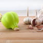 Lime green silicone garlic peeler next to whole garlic cloves.