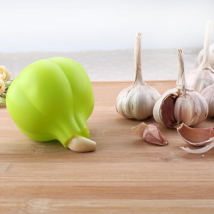 Lime green silicone garlic peeler next to whole garlic cloves.