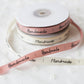 Pink "Handmade" satin ribbon roll with ribbon strips and loops