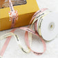 Yellow gift box with pink "Handmade" ribbon roll and ribbon pieces