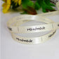 Silver/white satin "Handmade" ribbon in a loop, text visible