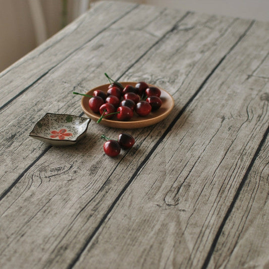 Linen tablecloth detail with gray woodgrain print and subtle line texture.