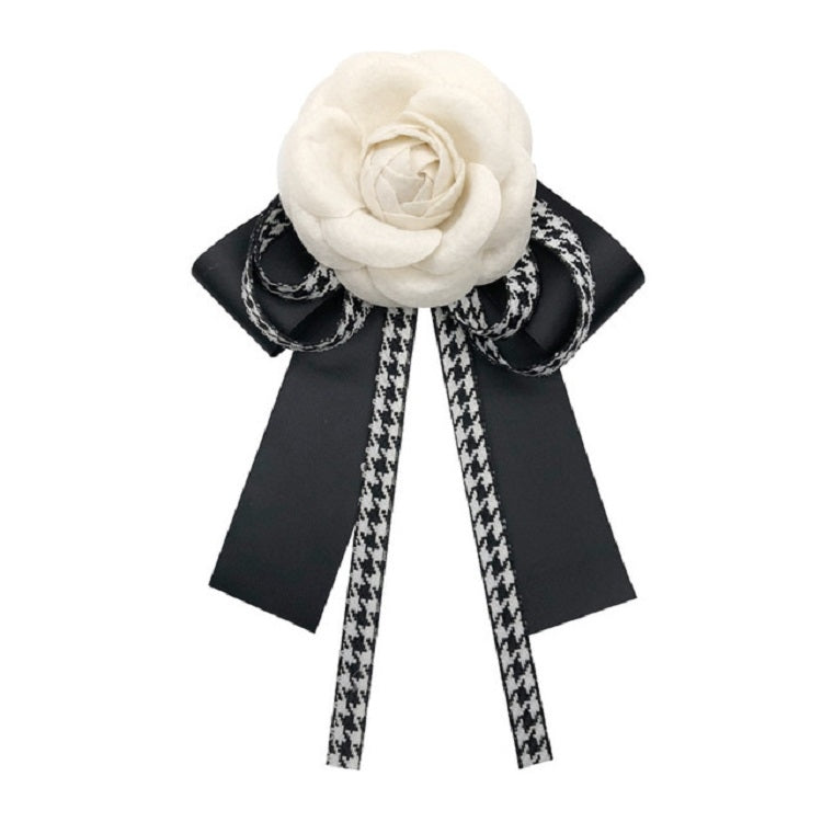 White fabric rose bow brooch with black ribbons and houndstooth tails