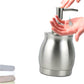 Stainless steel lotion dispenser bottle with pump handle, shown being pressed by hand