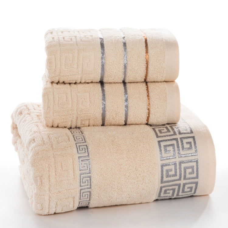 Stacked light beige cotton bath towels with blue and orange stripes and Greek key trim