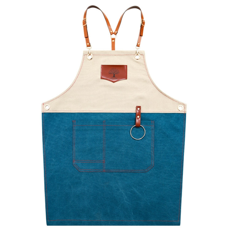 Two-tone denim apron with tan bib, blue body, front pocket, and adjustable leather straps