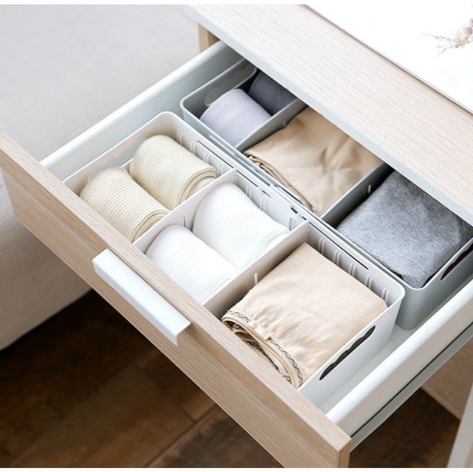 Sock storage box in a pull-out drawer with three compartments and folded socks
