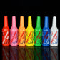 Row of colorful plastic squeeze bottles with ribbed caps and printed labels.