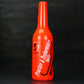 Orange plastic squeeze bottle with ribbed cap and printed bartending label.