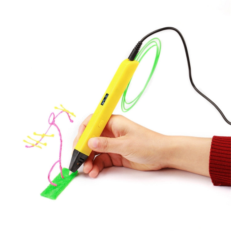 Yellow 3D printing pen with US plug, hand holding it while drawing green and pink shapes