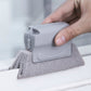 Window groove cleaning brush with gray scrub pad and light gray scraper held on window