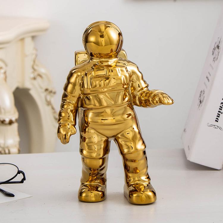 Gold astronaut ceramic vase figurine, walking-style pose with bent arm