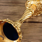 Ornate gold candle holder cup with embossed swirl pattern detail