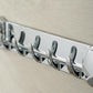 Chrome row towel hook with five curved hangers on suction-cup base