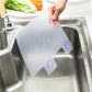 White splash-proof baffle board in a sink, water droplets on the surface.