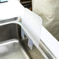 White splash-proof baffle board mounted in a sink with suction tabs attached.