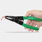 Green-handled wire stripper tool held in hand, showing black panel with wire markings