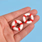 Mini lifebuoy rings, red-and-white striped, held in palm
