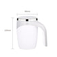 Electric white stirring cup with curved handle and stainless top.