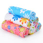 Folded microfiber cleaning towels with blue, pink, and green floral prints, rolled stack