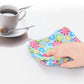 Microfiber floral cleaning cloth with multicolor flower print, hand wiping a countertop