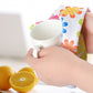 Microfiber floral cleaning cloth draped while drying a mug, orange and blue flower print