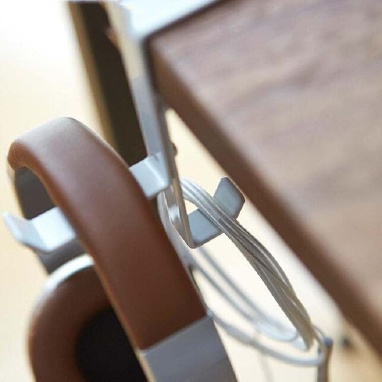 Close-up of brown over-ear headphones resting on the headset stand’s hook