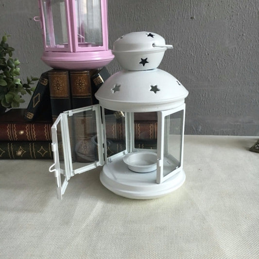 White metal lantern candle holder with star cutouts and hinged door detail on the frame.