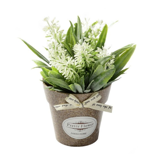 Artificial potted flowers with white blossoms and green leaves in a gray fabric pot