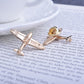 Gold retro airplane brooch pin, angled close-up on paper