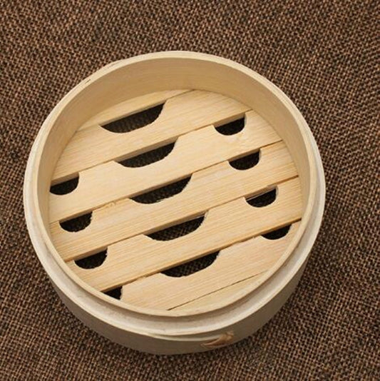 Round bamboo steamer basket with slatted insert, showing steam vents from above