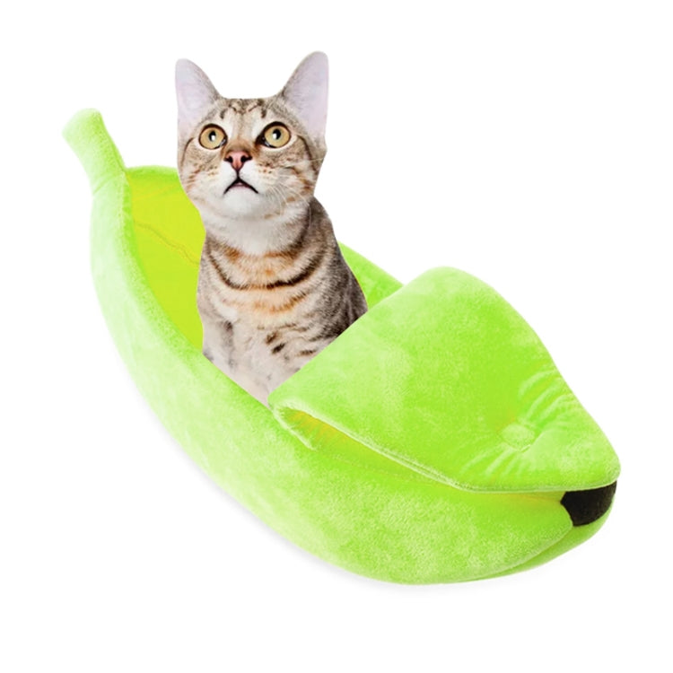 Banana-shaped pet nest with plush green cushion, cat curled inside
