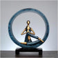 Blue and gold resin yoga pose statue featuring a seated meditating figure on a black base