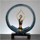Blue and gold resin yoga pose statue with a raised-arm figure inside a round ring