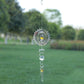 Star-shaped metal wind chime with yellow gem center and spiral wire hook