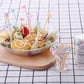 Fruit bowl topped with colorful cartoon cake forks and mini storage cup