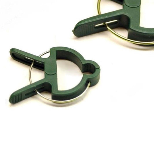 Close-up of green plastic plant clip with three metal spring prongs