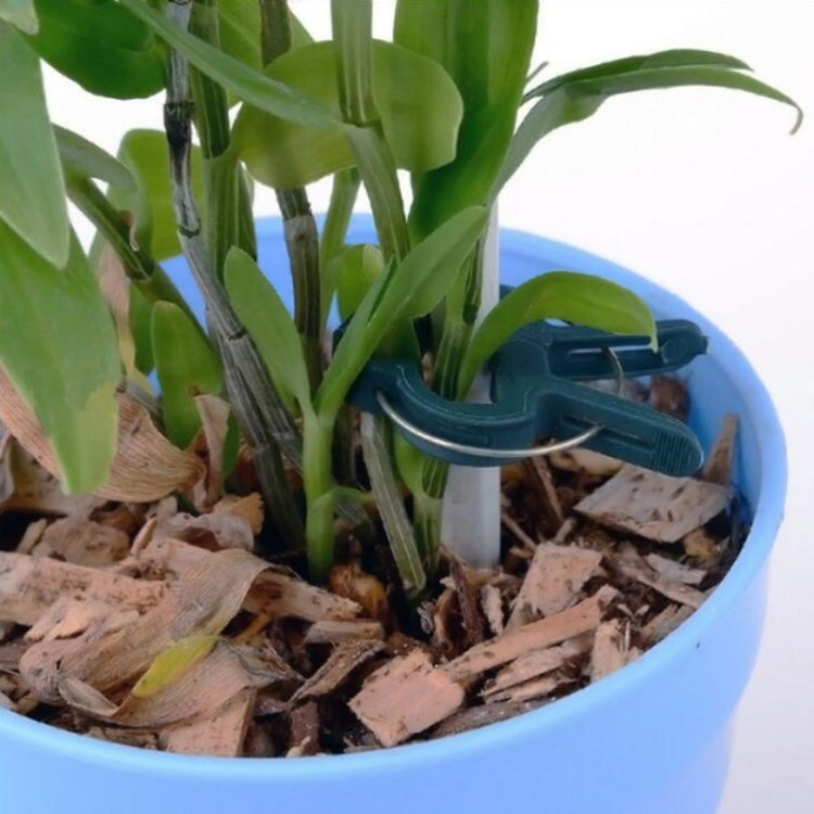 Green plant clip attached to a stake in a blue pot of mulch