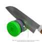 Knife sharpening tool with green grinding wheel grinding a kitchen knife edge