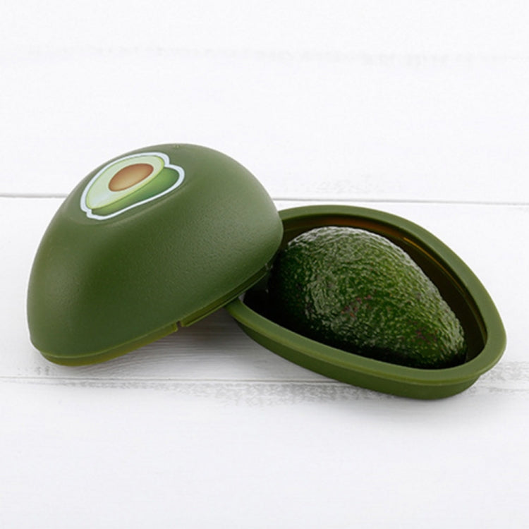 Avocado-green plastic crisper container open with lid and one green fruit inside.
