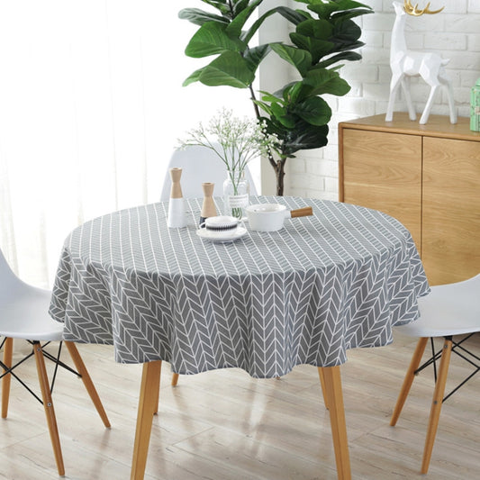 Gray round tablecloth with white chevron leaf pattern covering a dining table