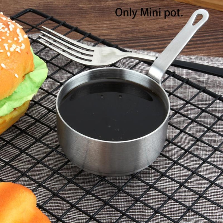 Stainless steel mini sauce pot with loop handle filled with dark liquid