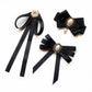 Set of three black ribbon collar bows with faux pearl centers