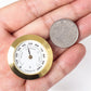 Gold 38mm hygrometer gauge held in hand, shown with coin for size
