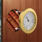 Gold hygrometer mounted on wooden surface with dial visible and case opening