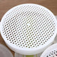 White perforated steaming plate with many holes for microwave steamer