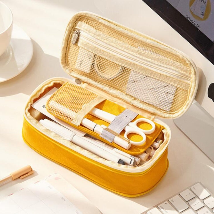 Flexible mesh pencil case with zipper, yellow shell showing organized school stationery