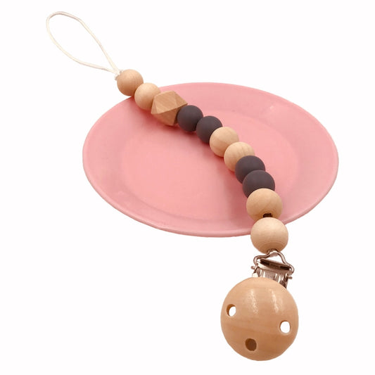 Wooden baby pacifier clip with tan and dark beads and a round face teether charm