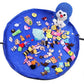 Blue round toy storage bag with colorful stuffed toys laid inside