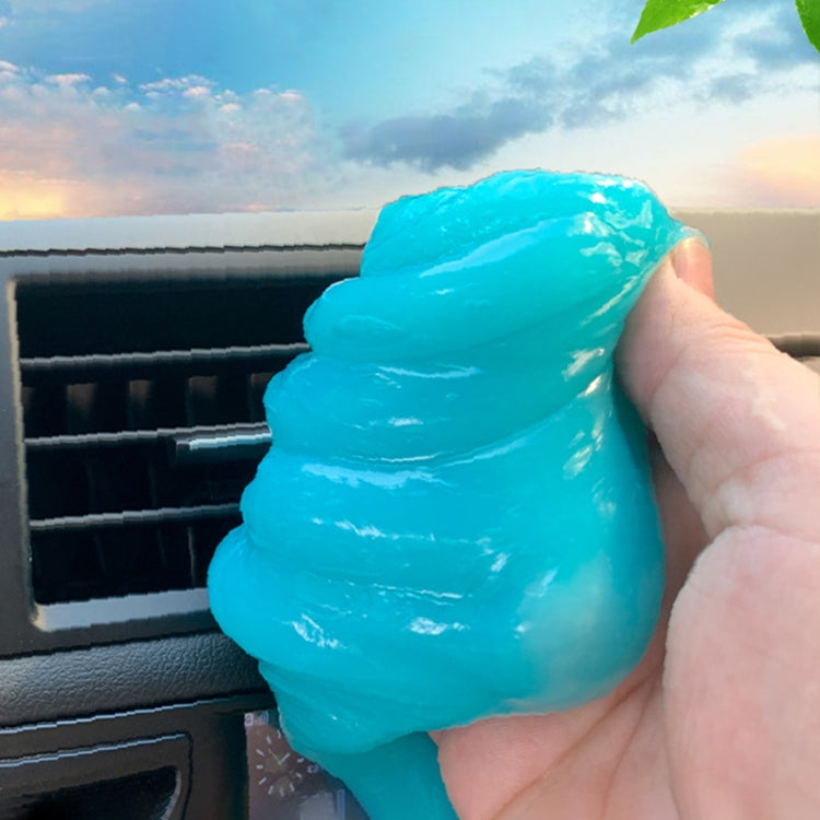 Sky blue car cleaning gel sticker pressed on dashboard vent with hand